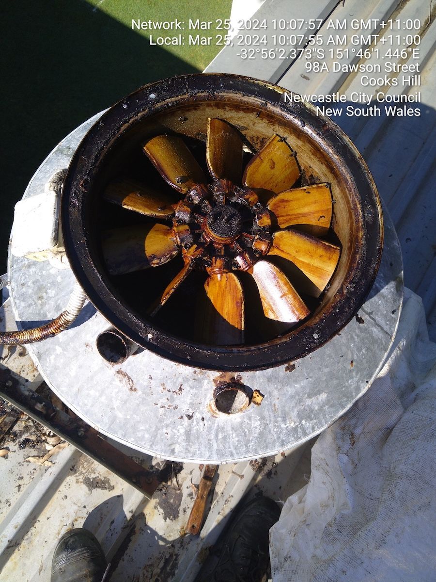 Top-down view of a rusty fan inside a round, metal housing on a rooftop — Central Coast Commercial Kitchen Cleaning in Tuggerah, NSW