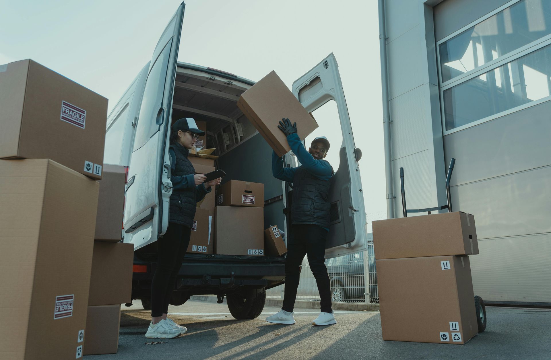 Two men are loading boxes into a van.