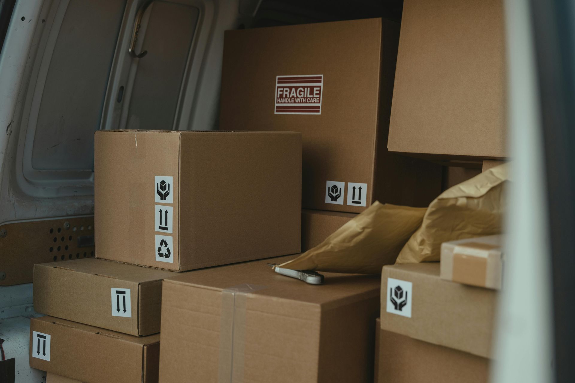 A stack of cardboard boxes in the back of a van.