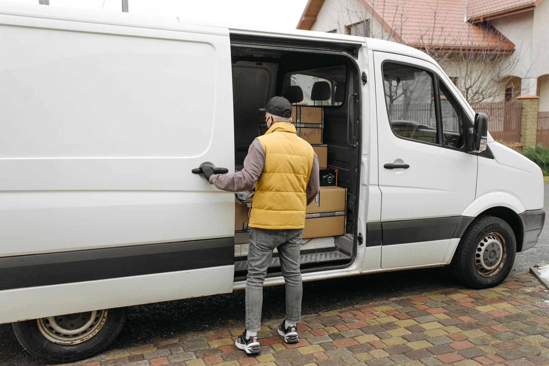 A man is loading boxes into a white van.