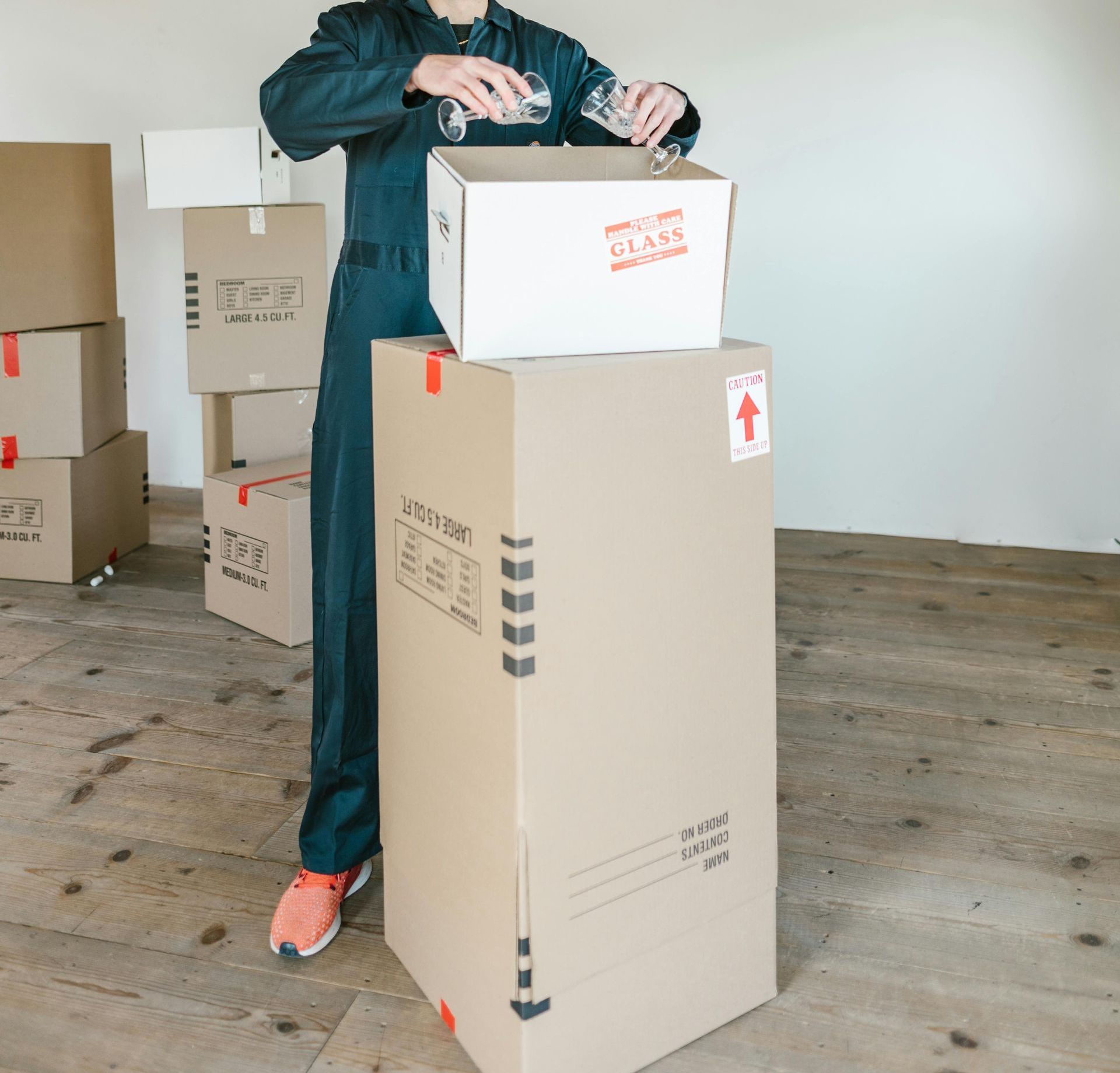 A man is standing next to a cardboard box that says fragile on it