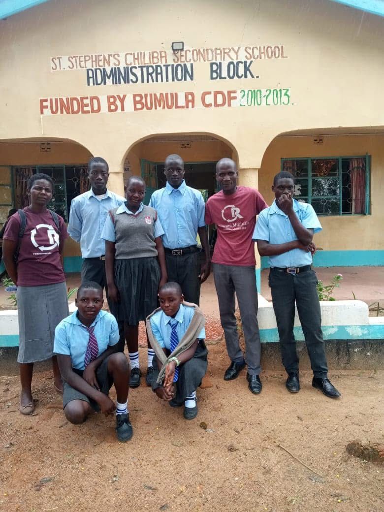 Group of people in front of a building labeled 