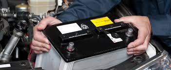 Mechanic performing car battery test at auto repair shop in Florida