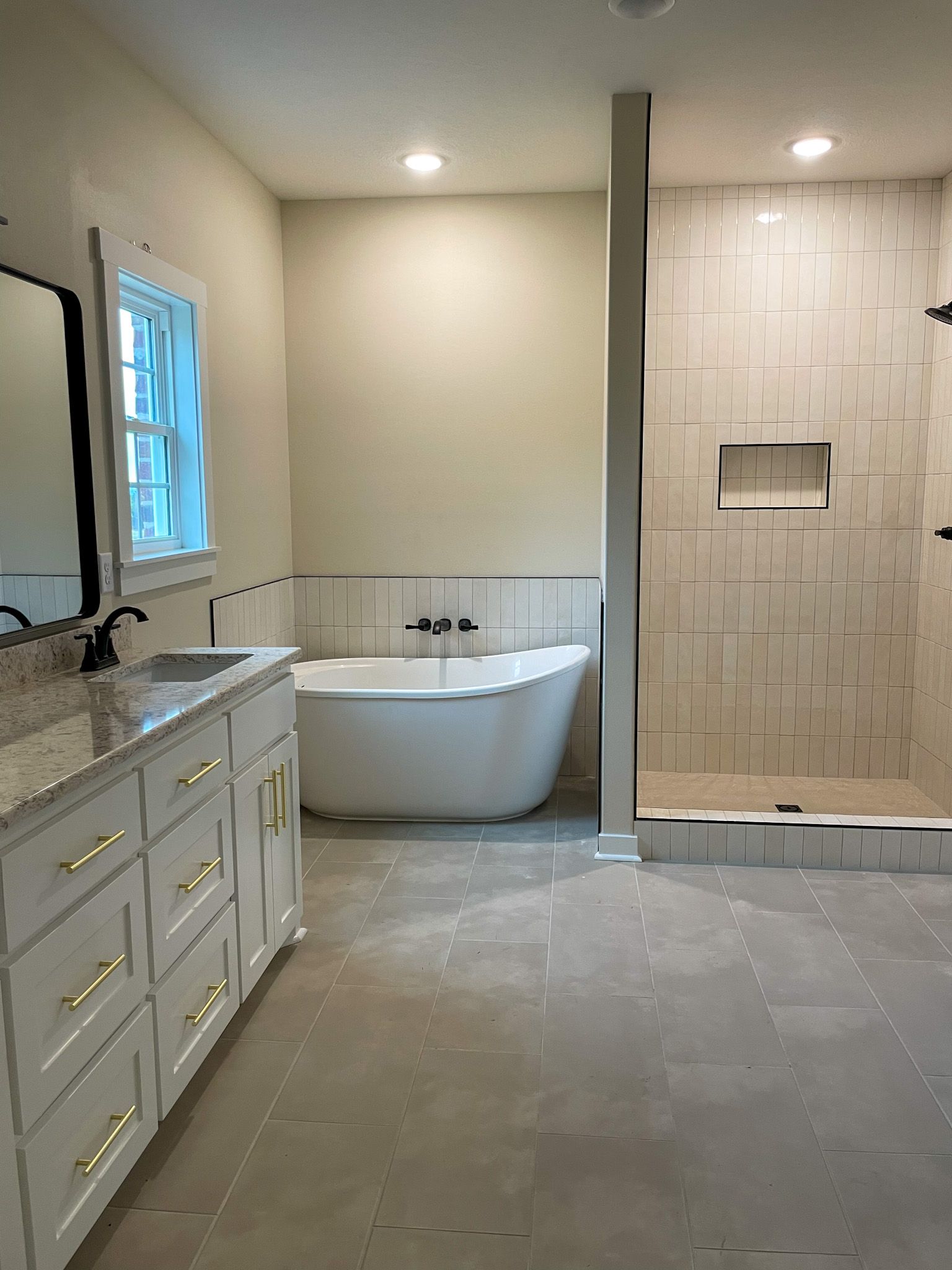 A remodeled bathroom with a tub , sink , mirror and shower.