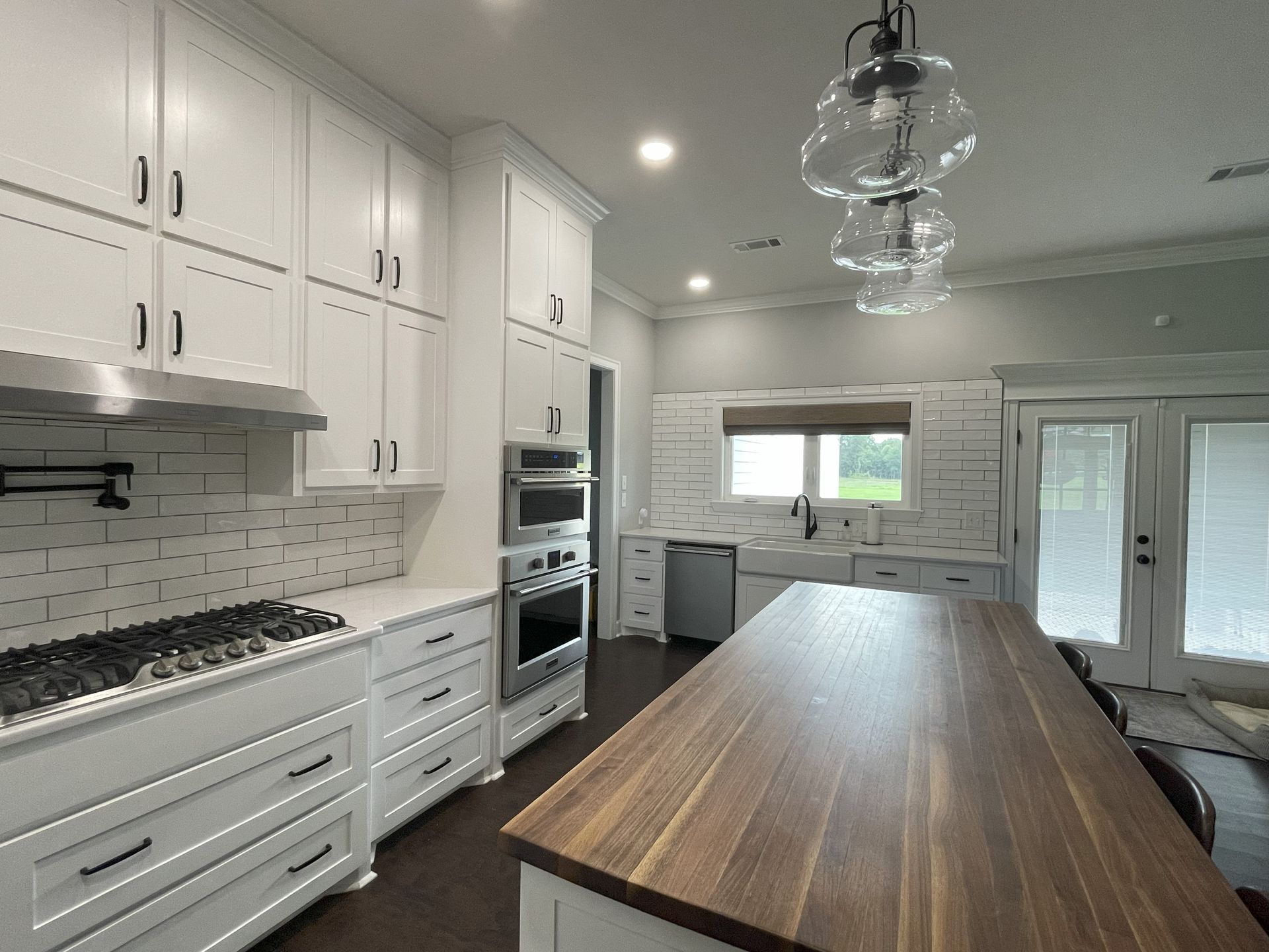 Large custom home kitchen with white cabinets and a large island counter.