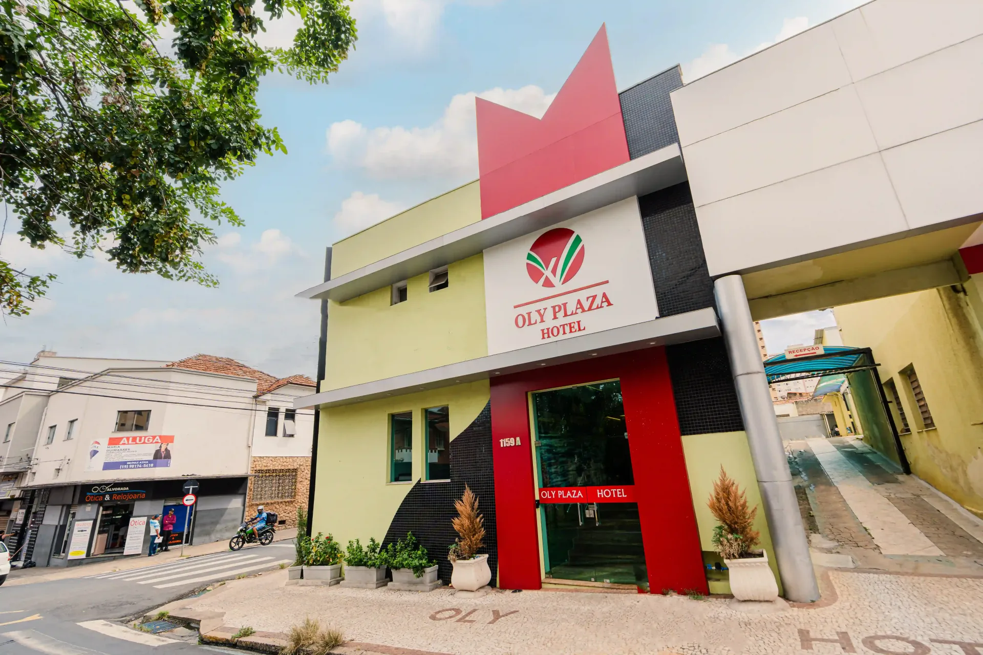 Um quarto de hotel com três camas e uma parede verde Oly Plaza Hotel