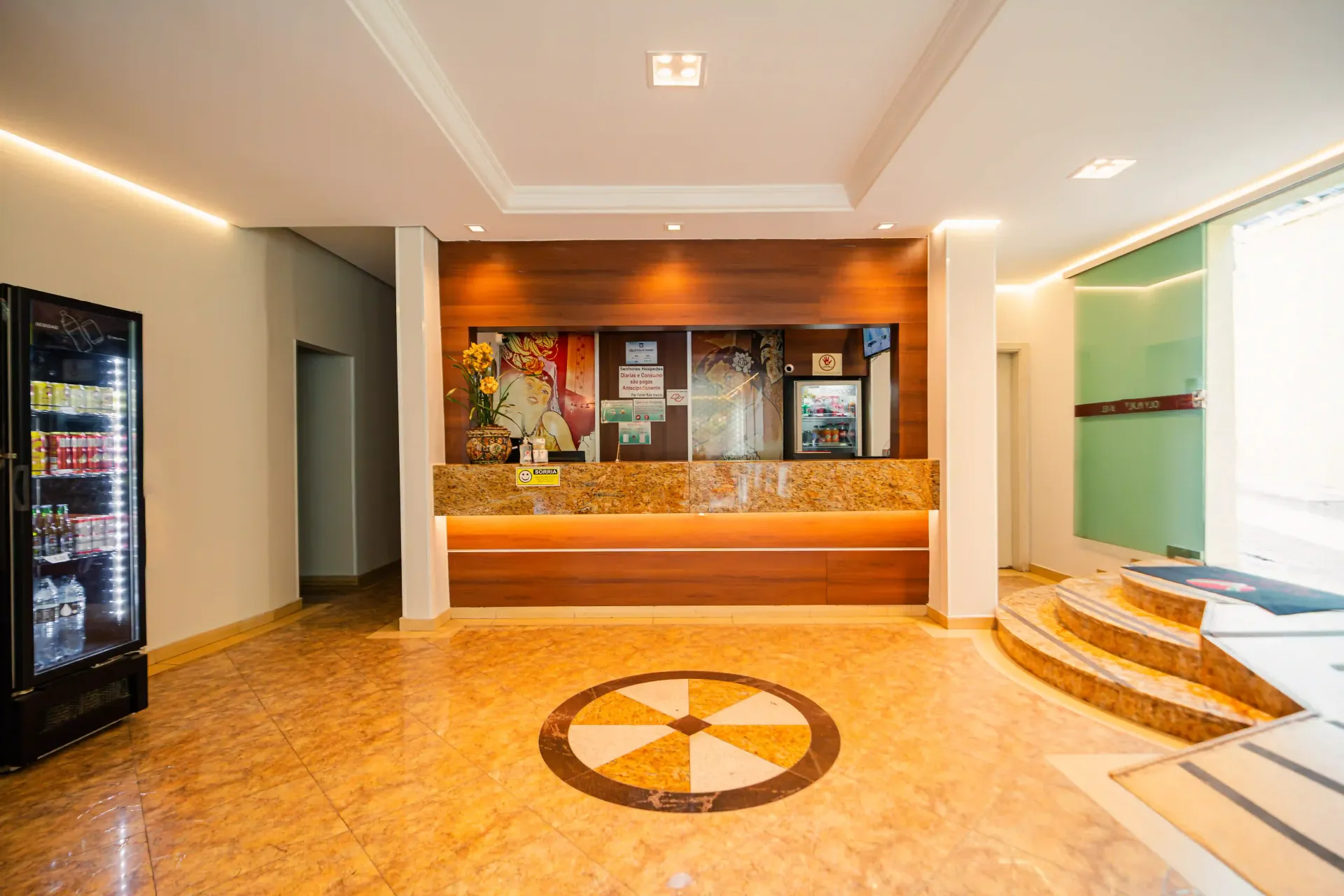 Um quarto de hotel com três camas e uma pintura na parede Oly Plaza Hotel