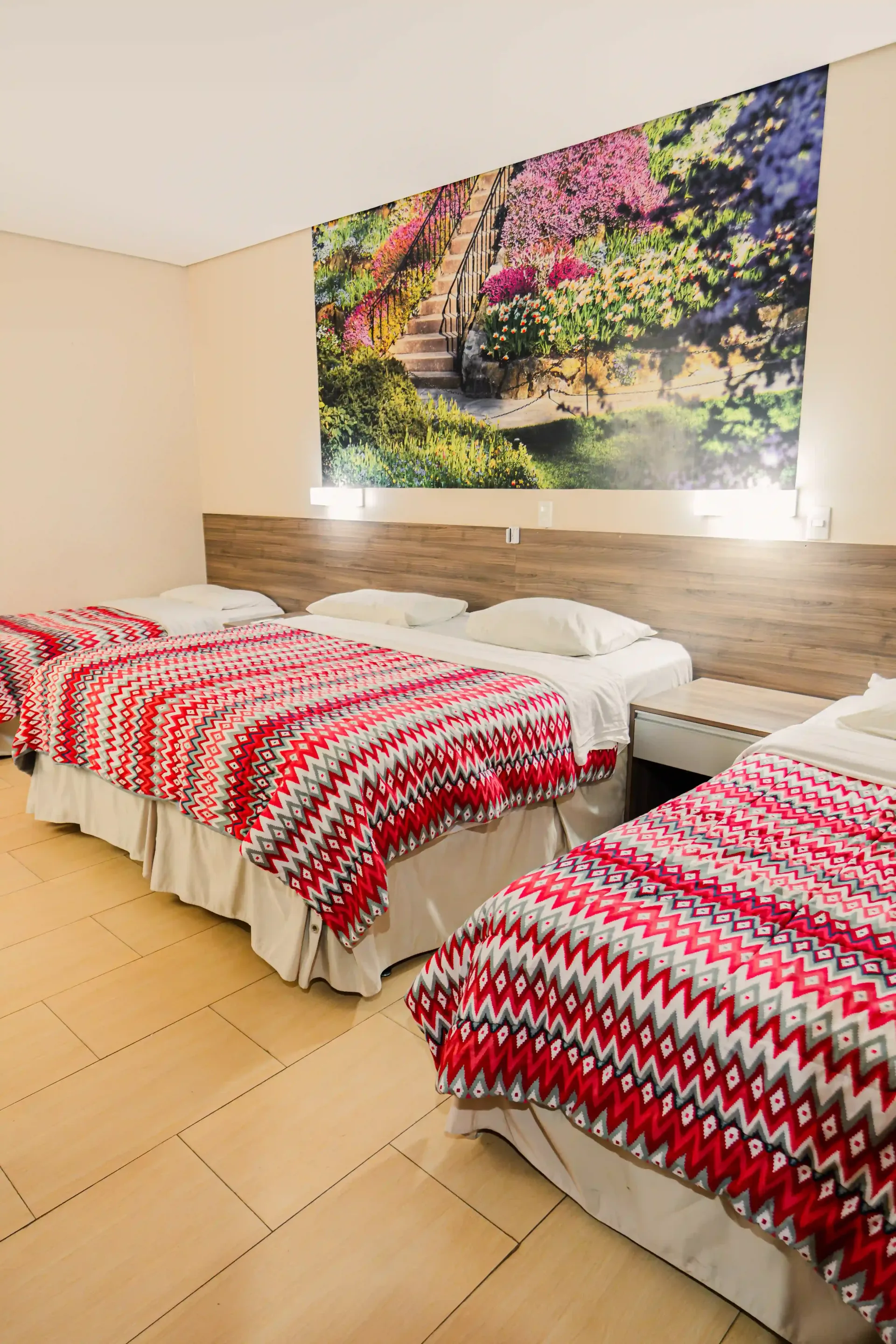 Um quarto de hotel com três camas e um quadro na parede Oly Plaza Hotel