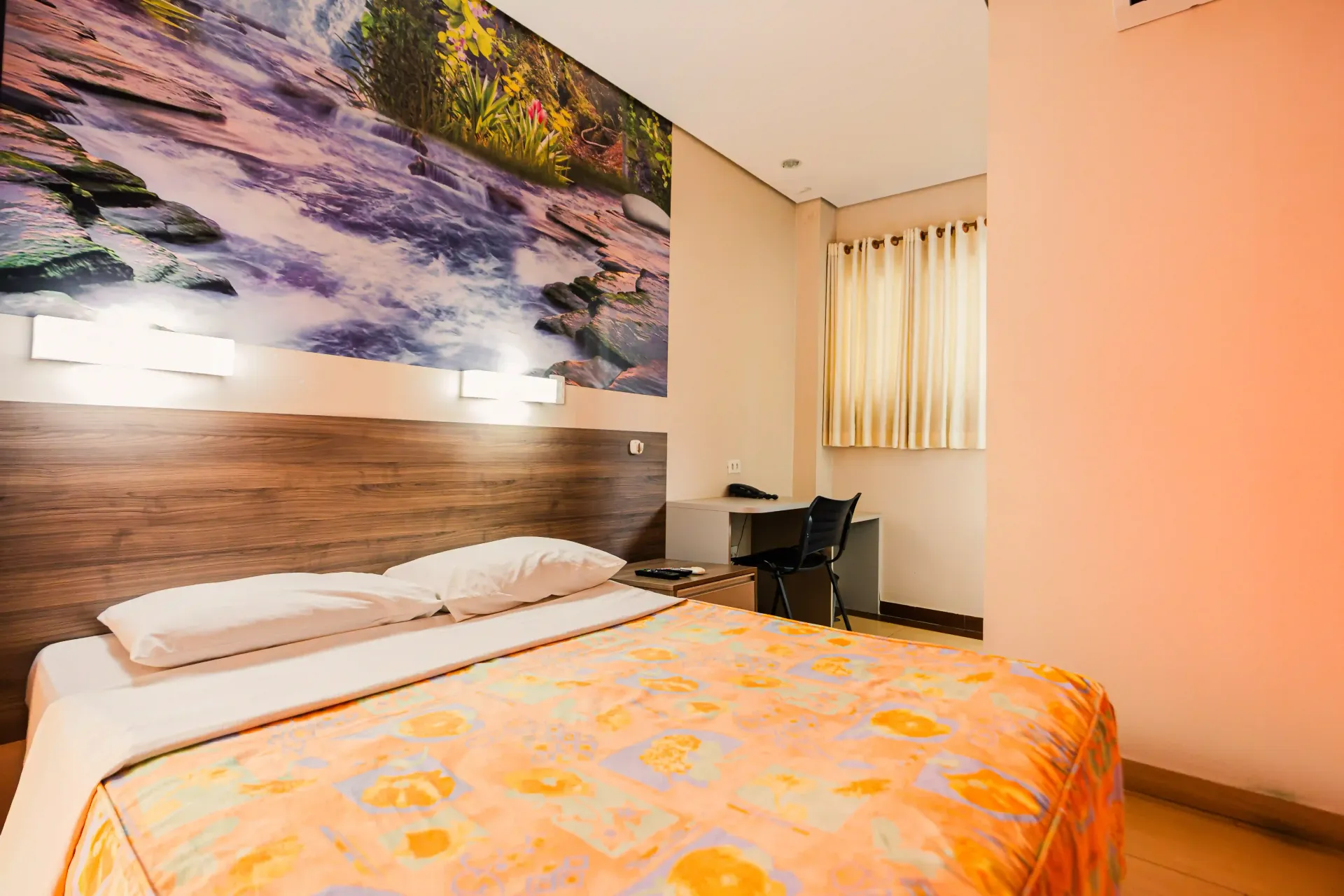 Um quarto de hotel com uma cama grande e uma pintura na parede Oly Plaza Hotel