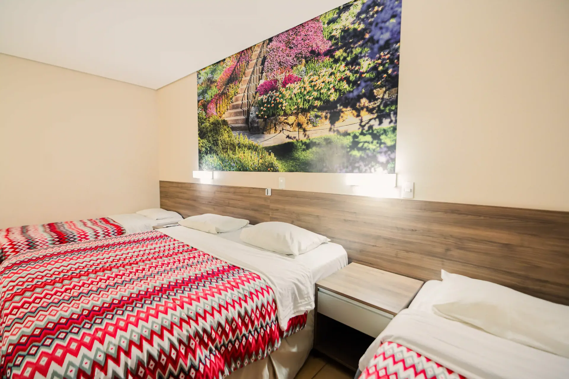 Um quarto de hotel com duas camas e uma pintura na parede Oly Plaza Hotel