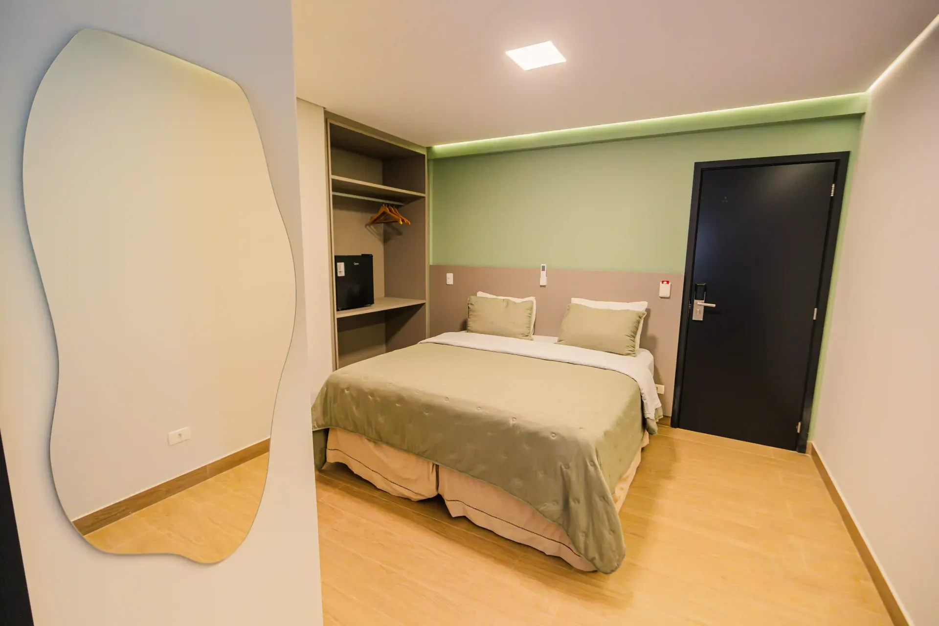 Um quarto de hotel com duas camas, uma escrivaninha e uma televisão Oly Plaza Hotel