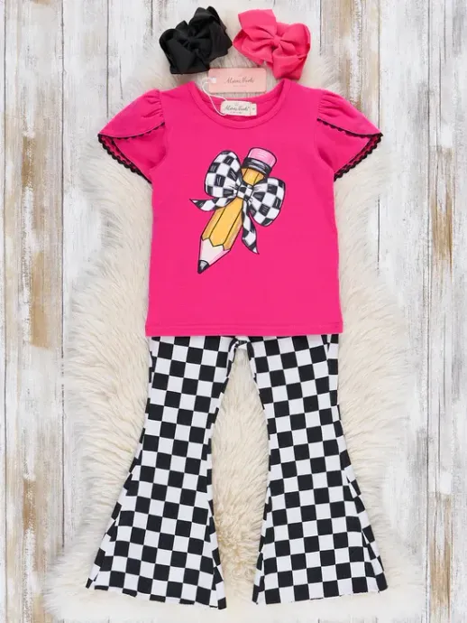Pink kids' outfit with checkered bow graphic and black-and-white flared pants, laid on wood background