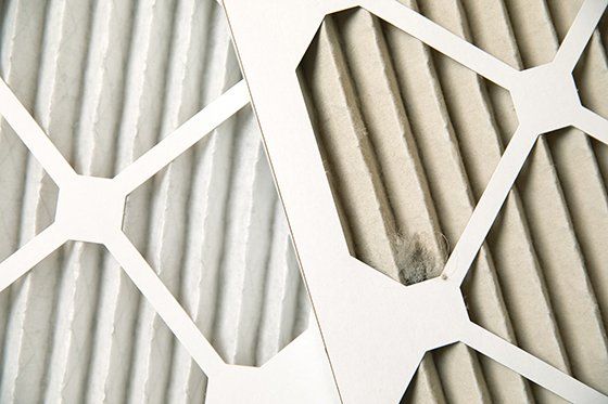 A side-by-side comparison of a new furnace filter and a used furnace filter.