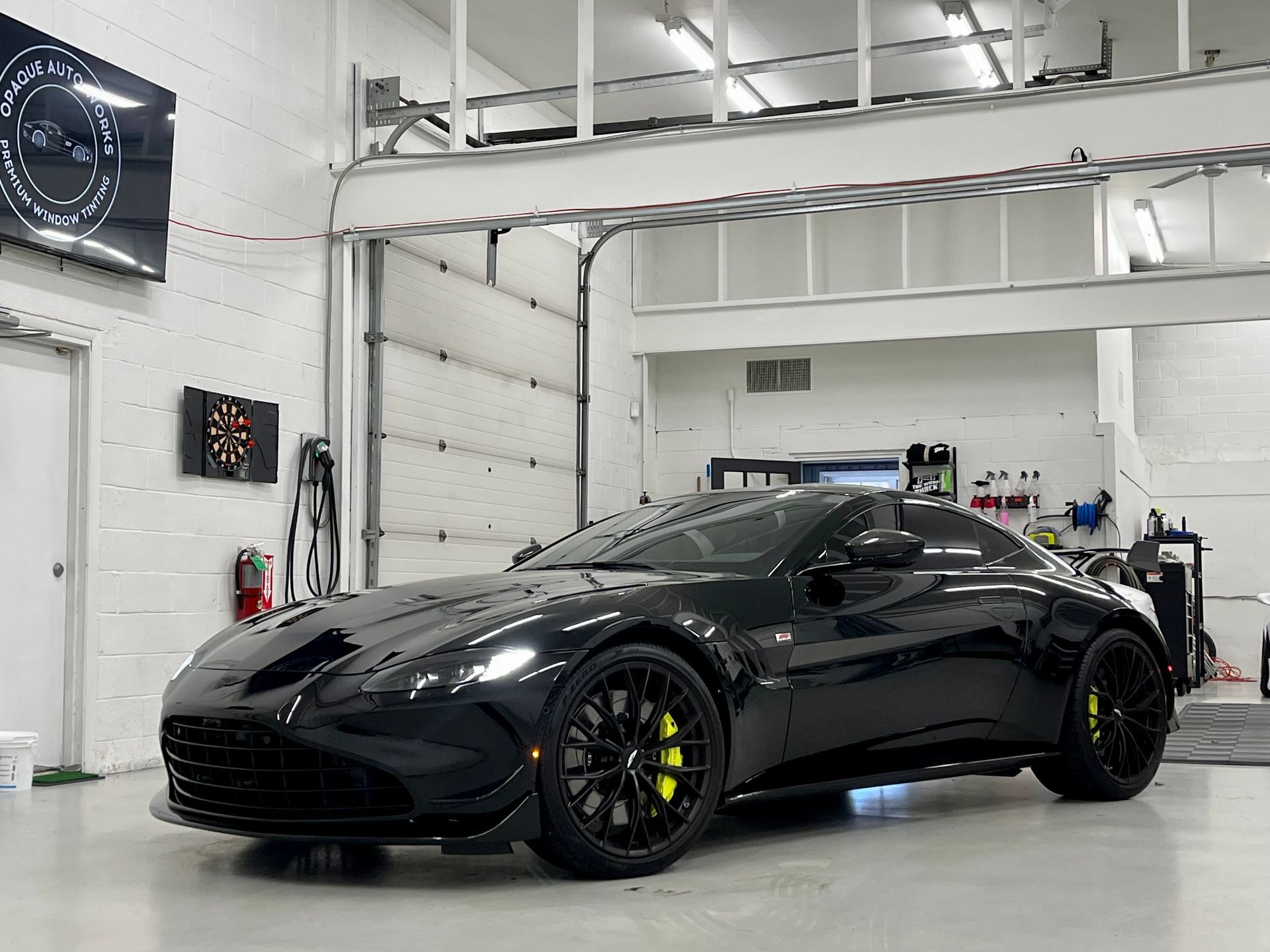A black sports car is parked in a garage.