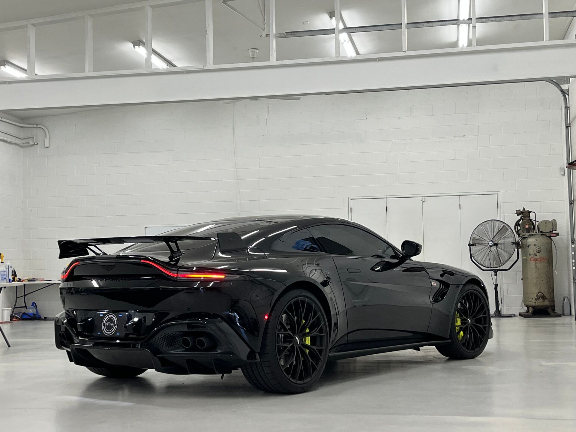 A black sports car is parked in a garage.