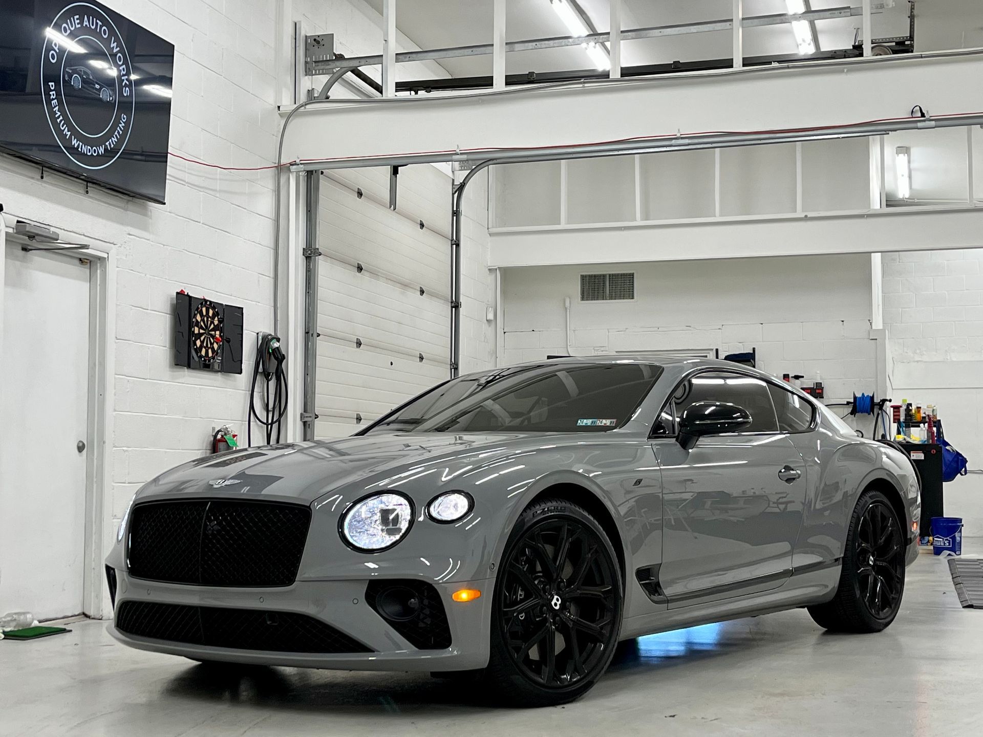 A bentley continental gt is parked in a garage.