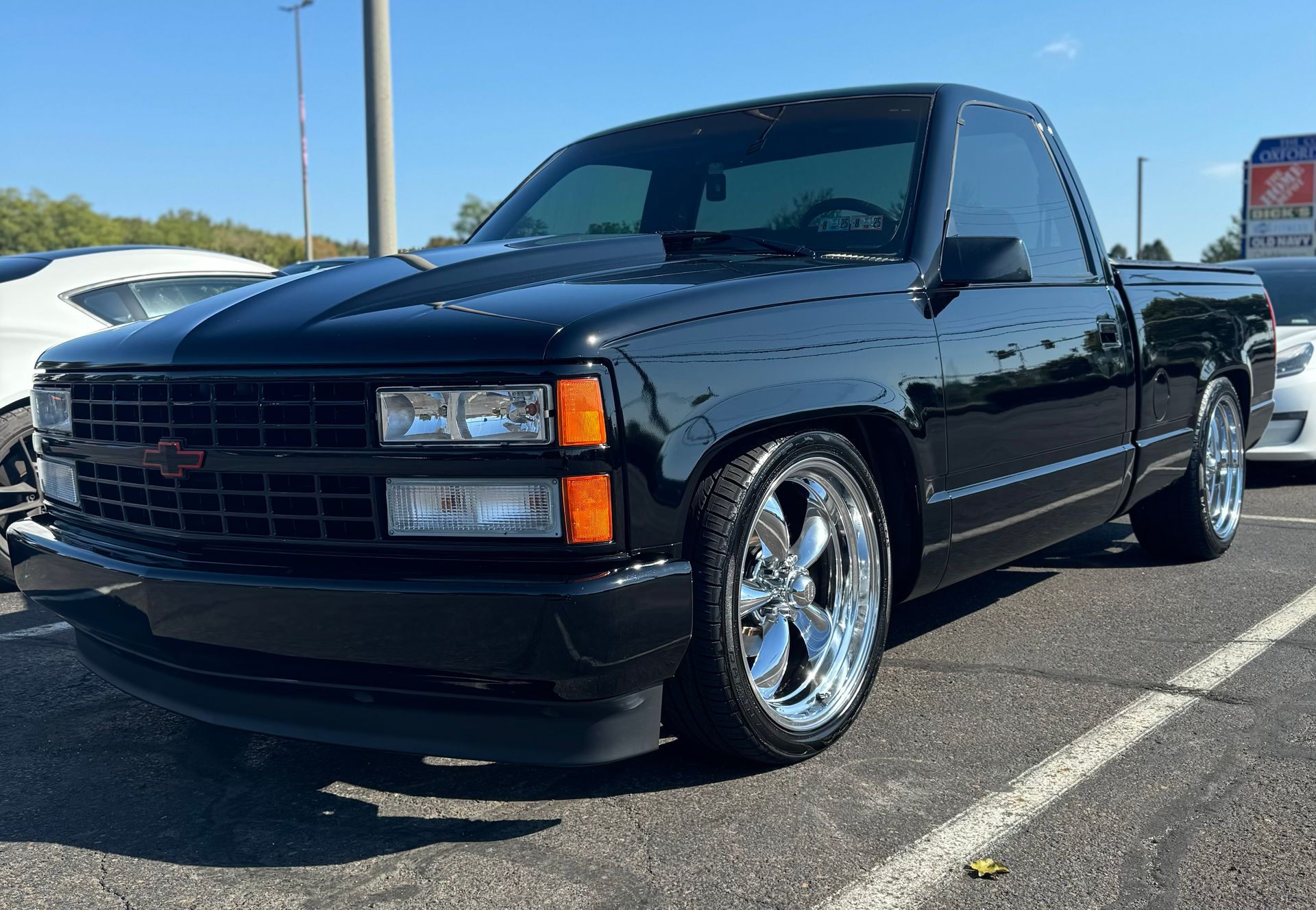 A black truck is parked in a parking lot.