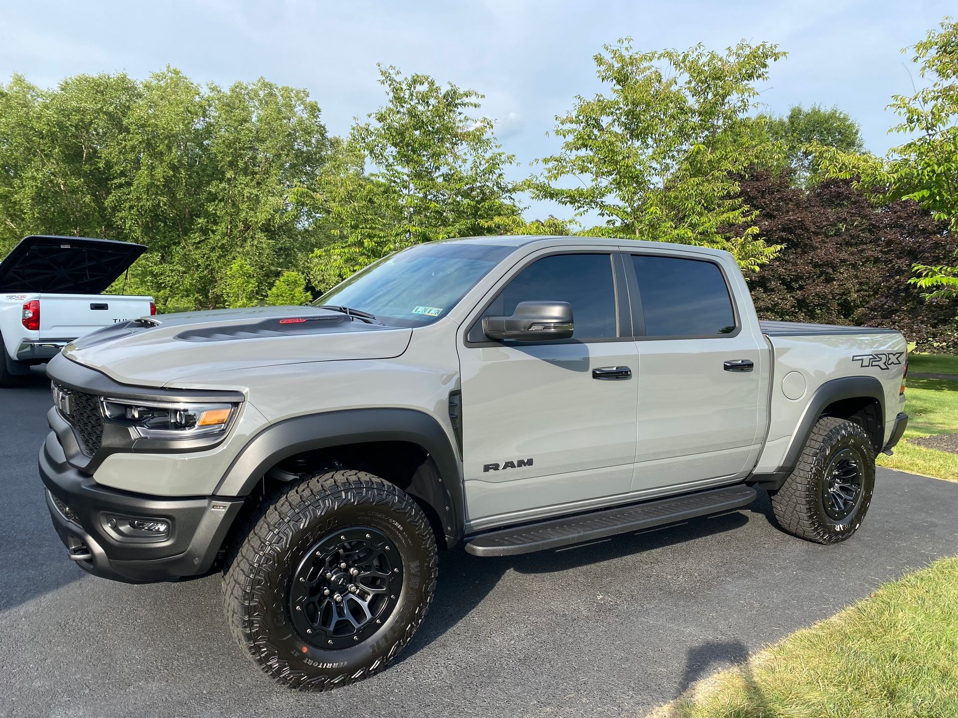 A gray ram truck is parked in a driveway.