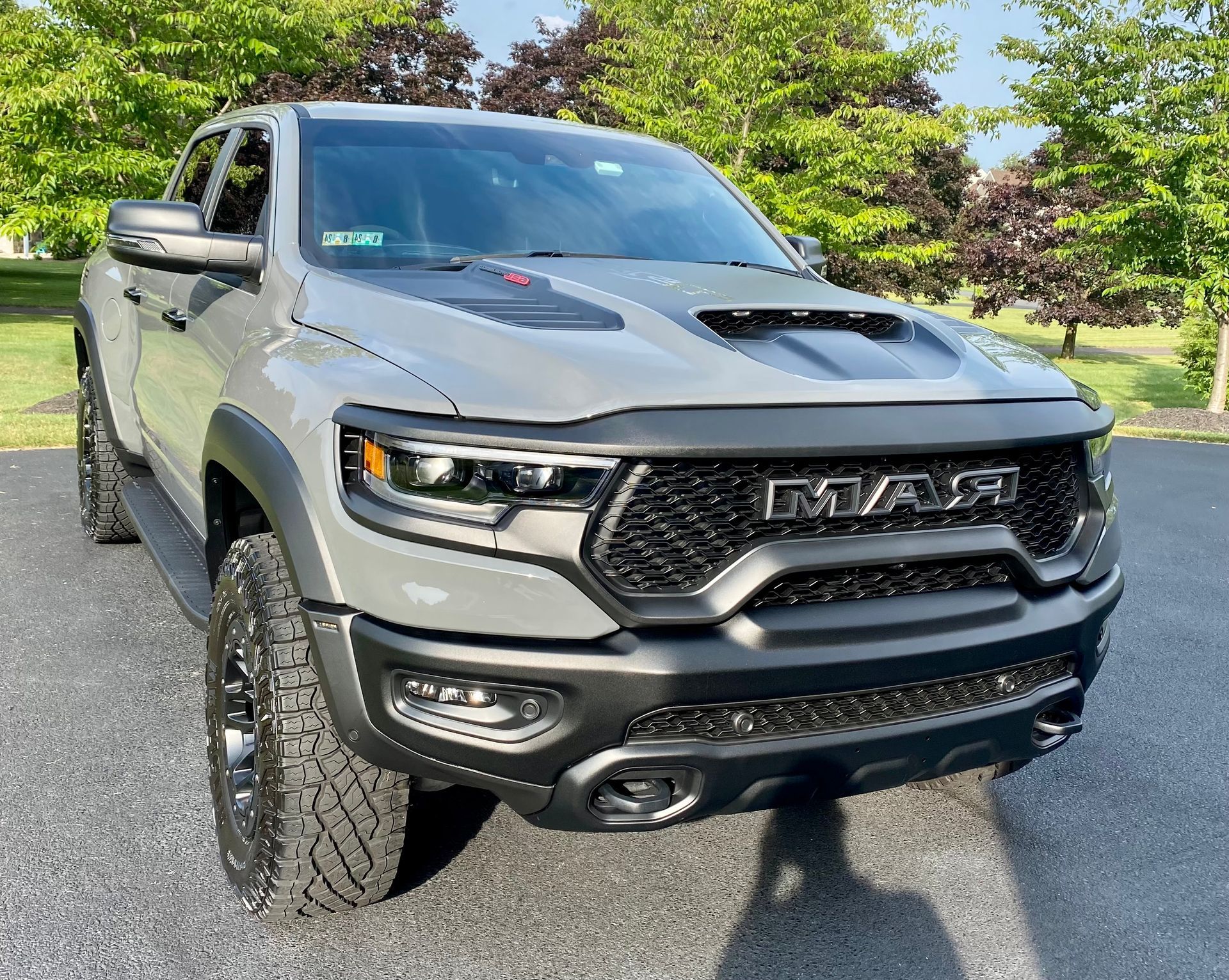 A gray ram truck is parked on the side of the road.