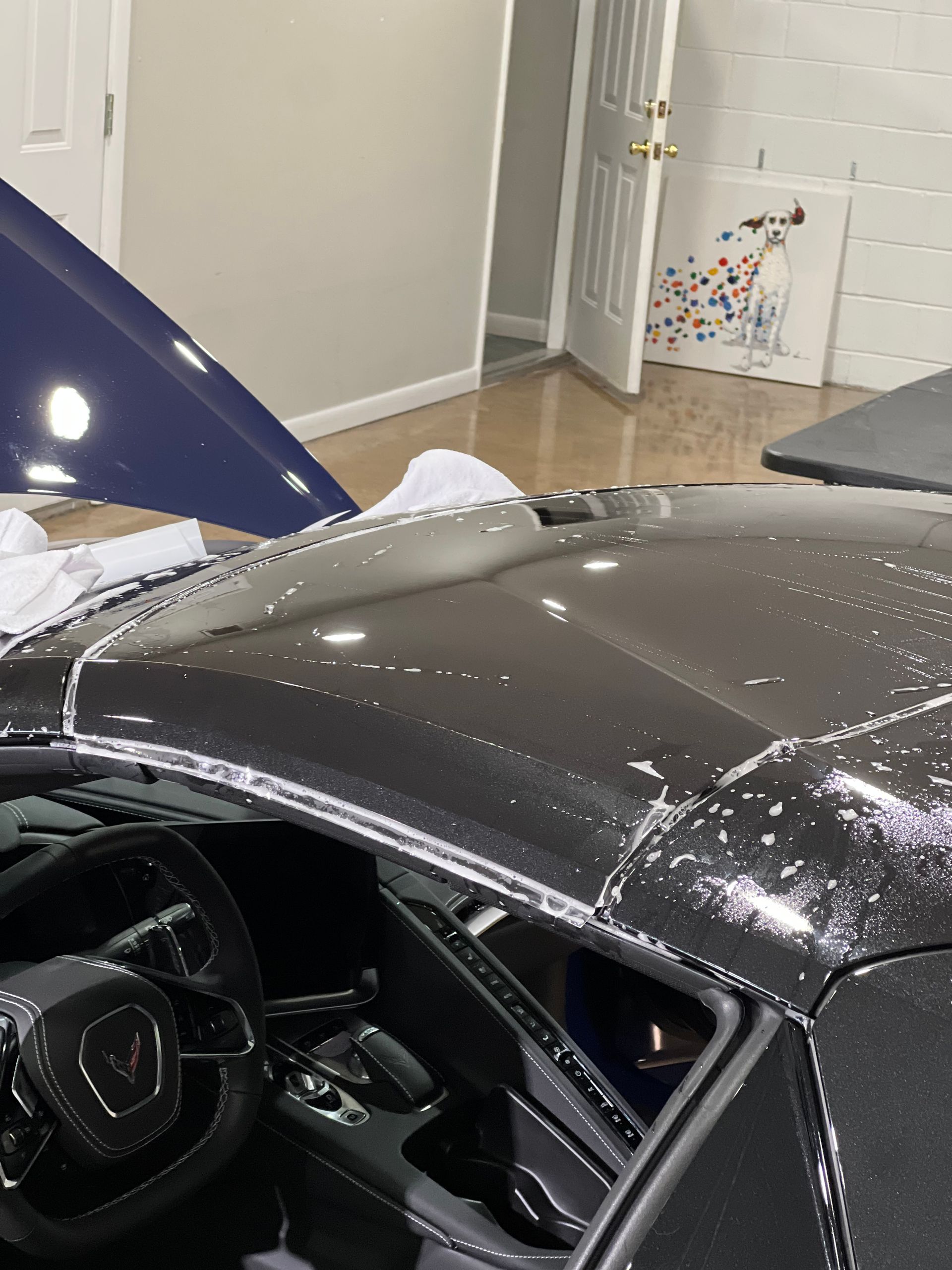 A car with the hood open is sitting in a garage.