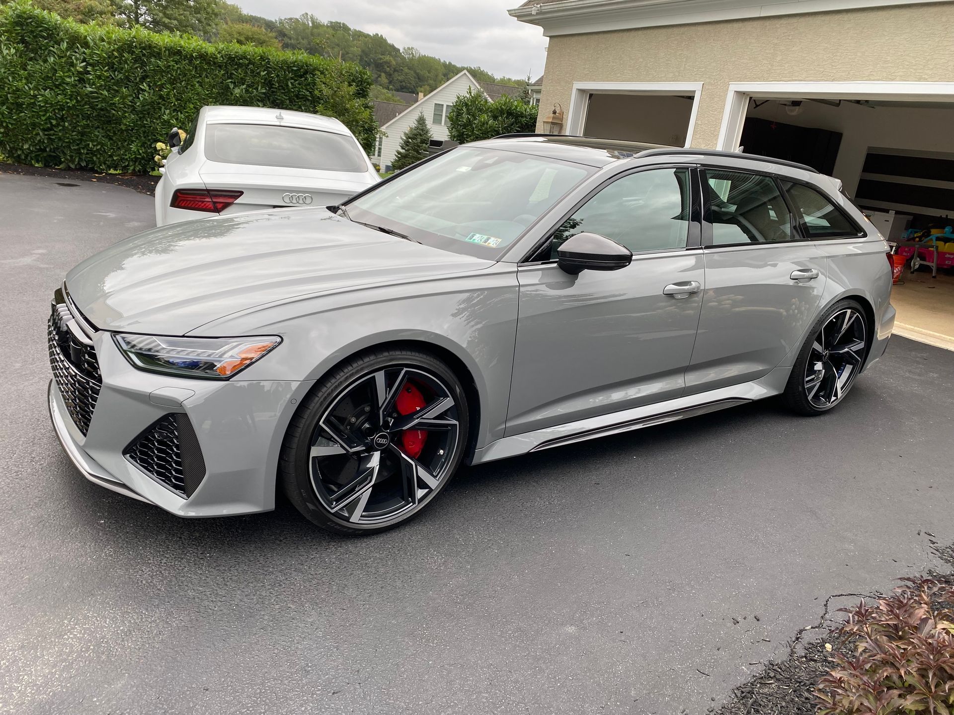 A gray audi rs6 is parked in a driveway next to a garage.