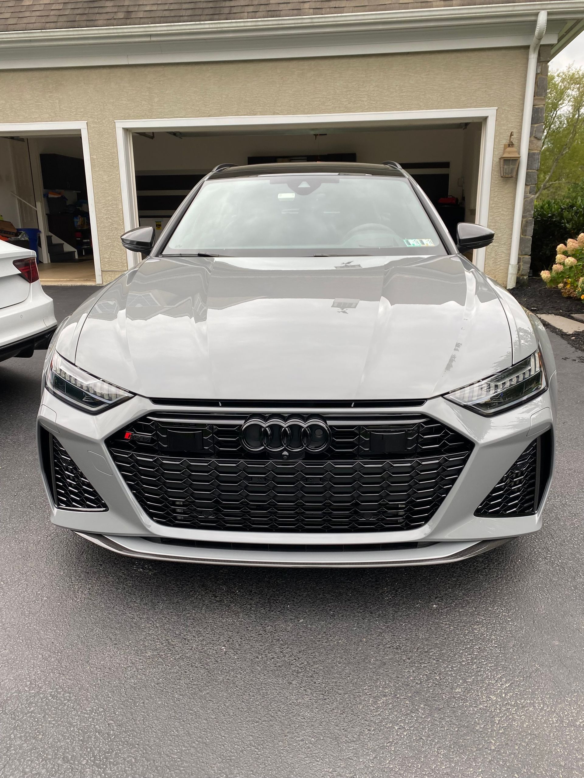 A gray audi rs6 is parked in front of a garage.