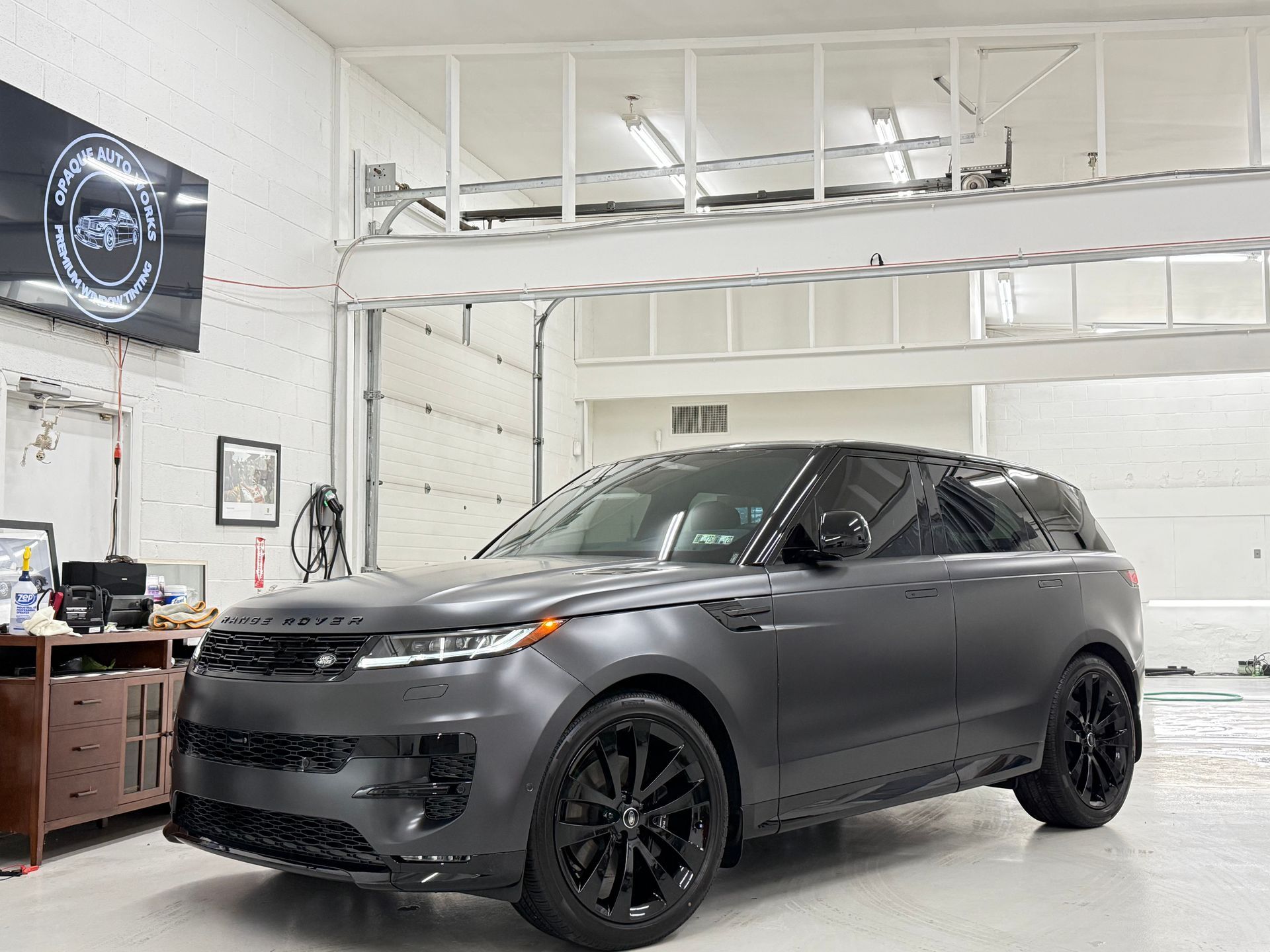 A black range rover is parked in a garage.