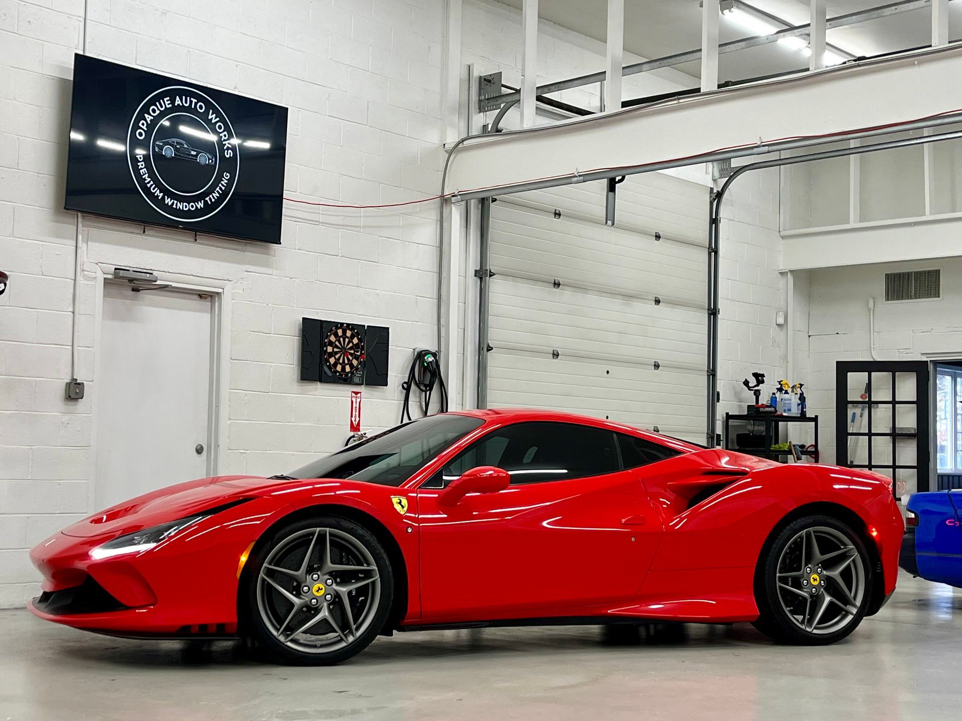 A red ferrari 488 gtb is parked in a garage.