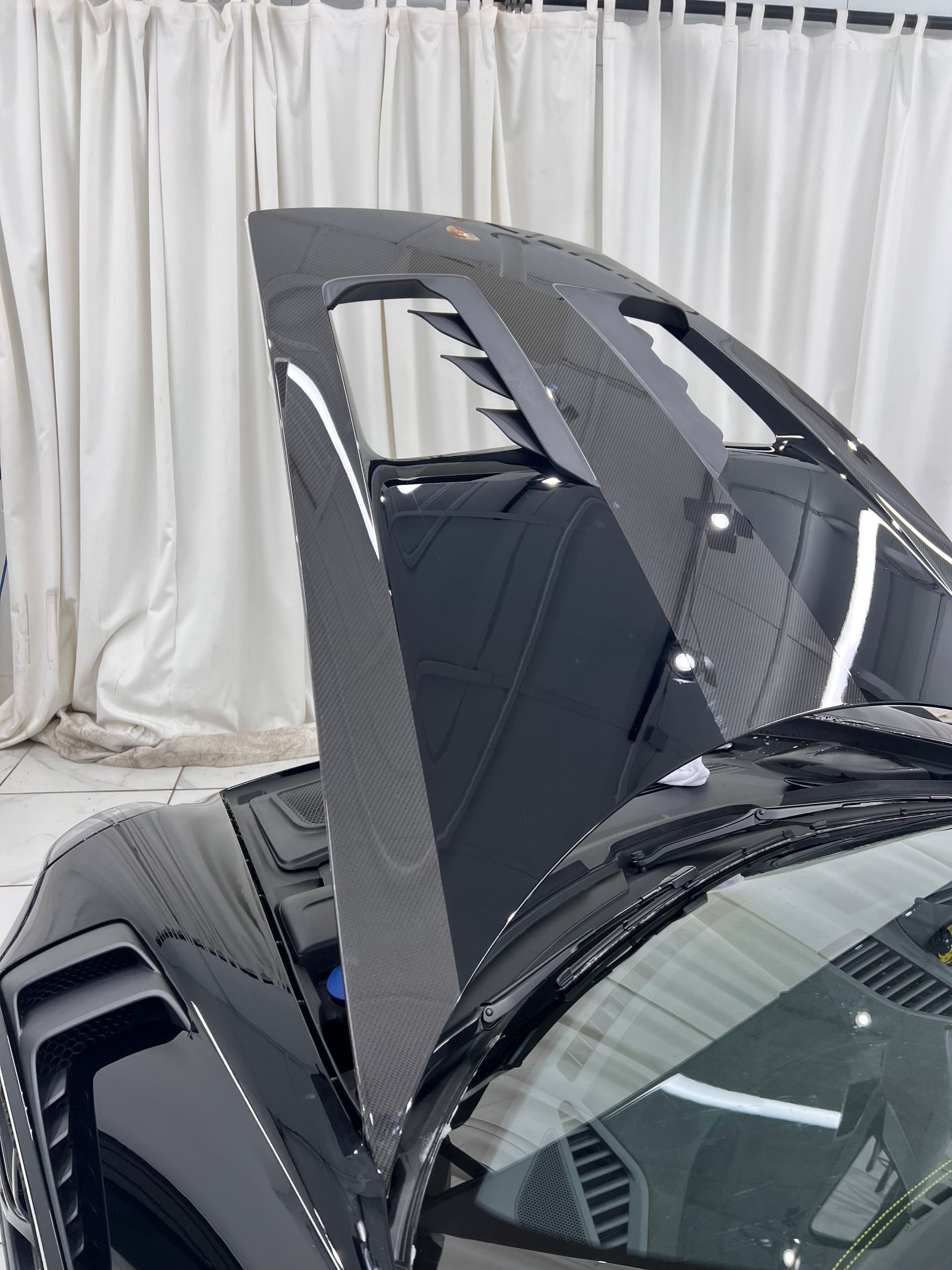 The hood of a black sports car is open