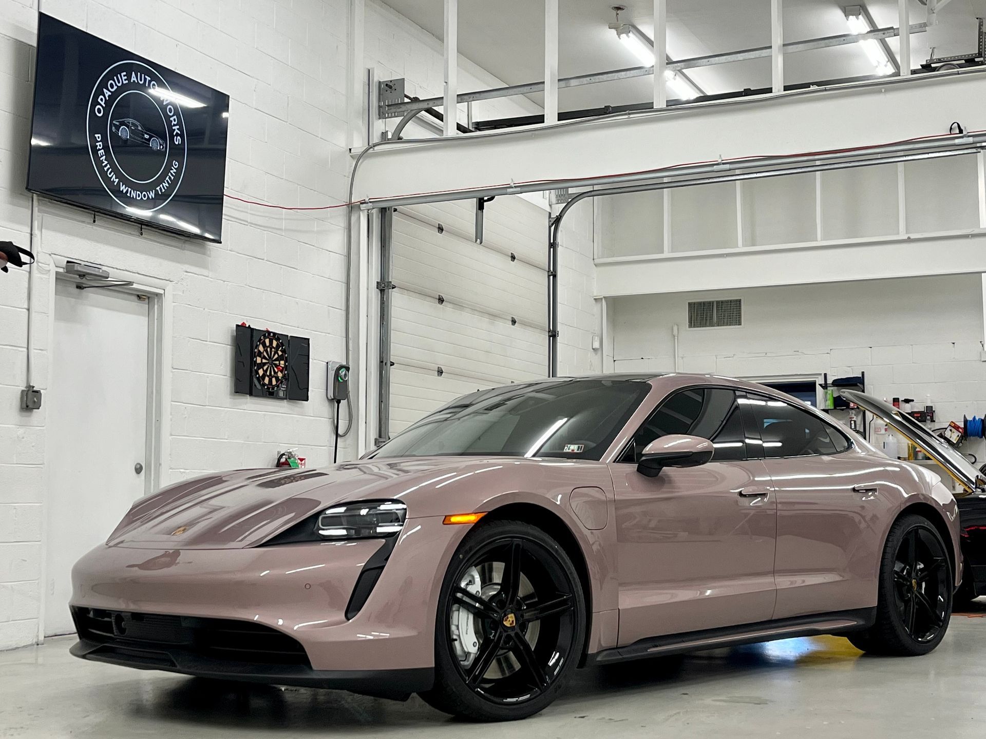 A porsche taycan is parked in a garage.