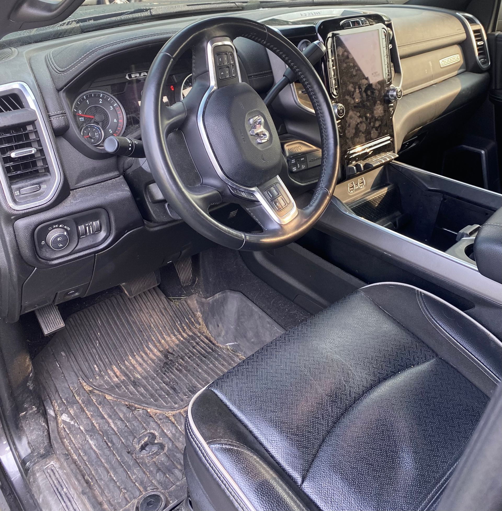 The interior of a ram truck with a steering wheel and seats