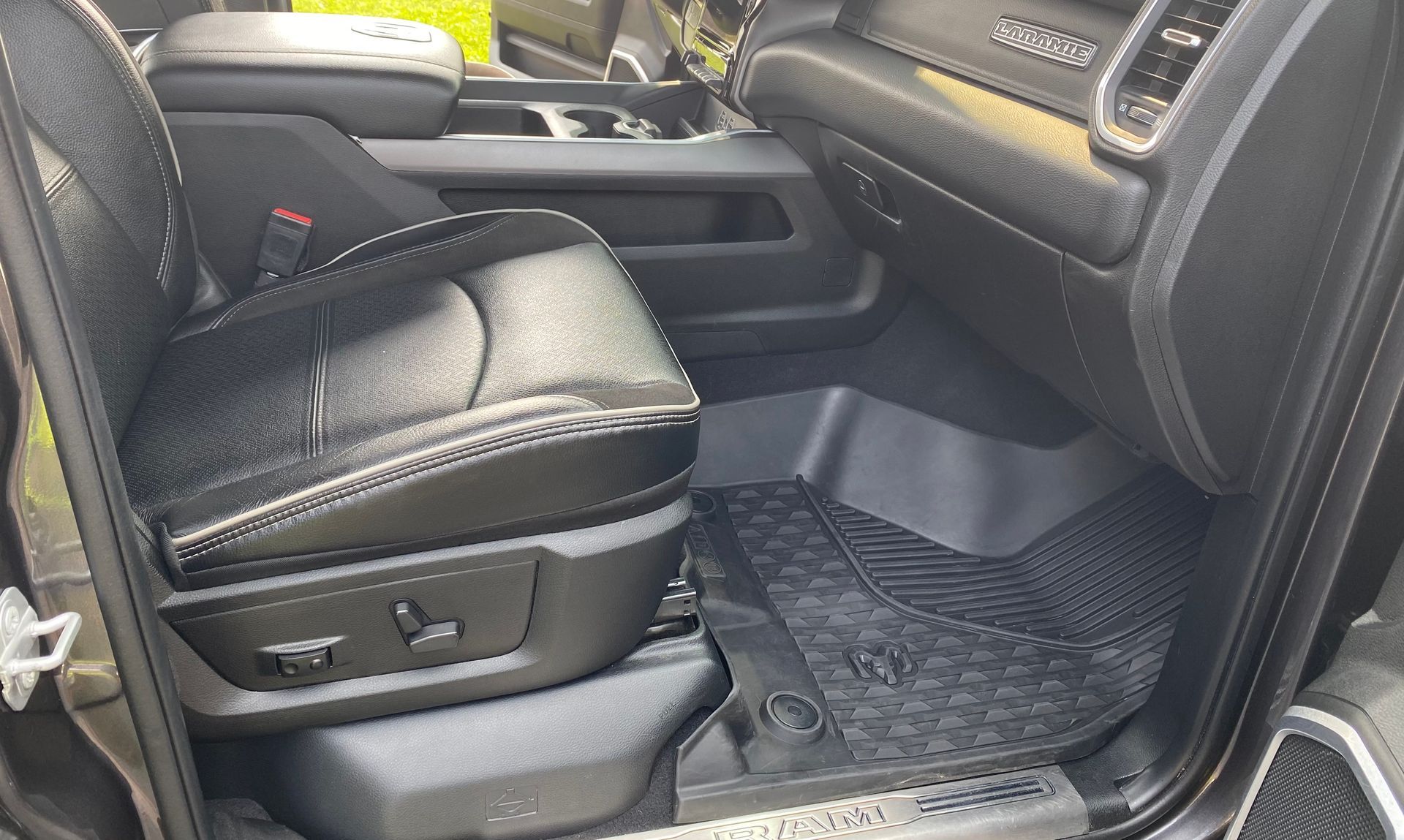 The interior of a ram truck with the seats up and the door open.