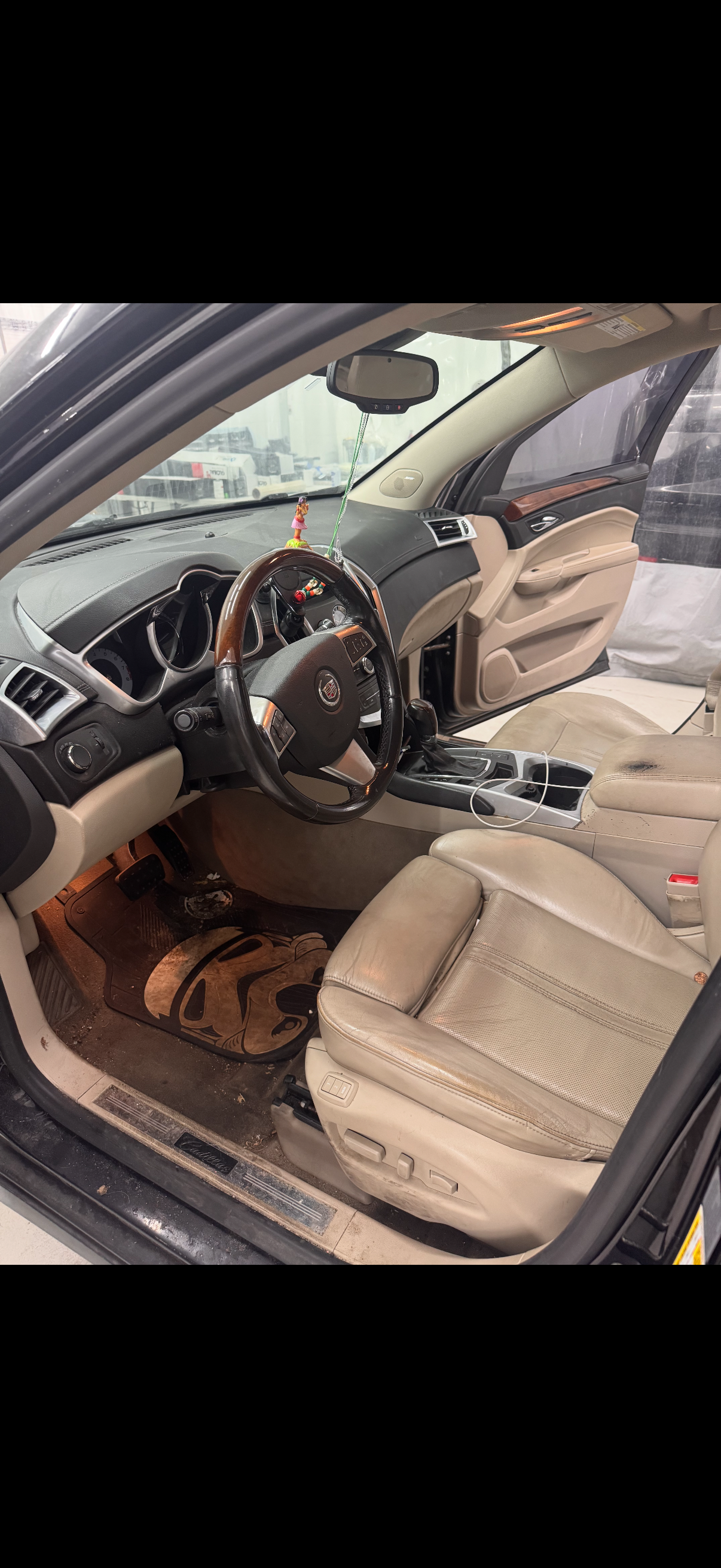 The inside of a car with a steering wheel and seats.