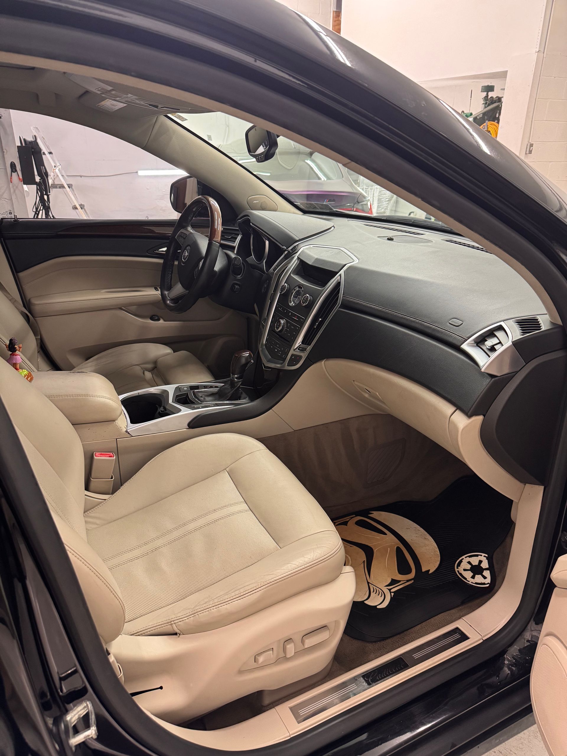 The interior of a black car with the door open.