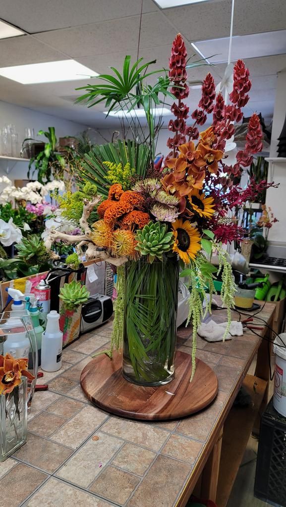 A large vase filled with flowers is sitting on top of a wooden table.
