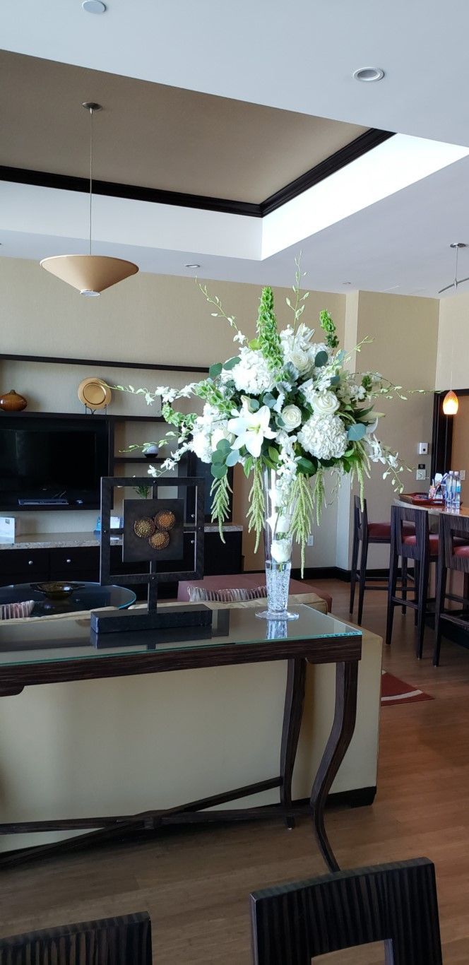 A vase of flowers is sitting on a table in a living room.