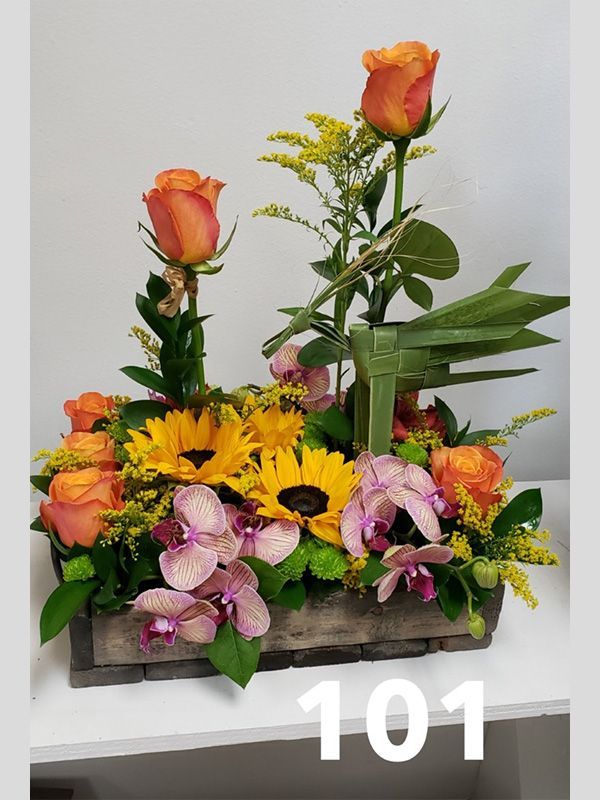 A wooden box filled with flowers and the number 101 on the bottom