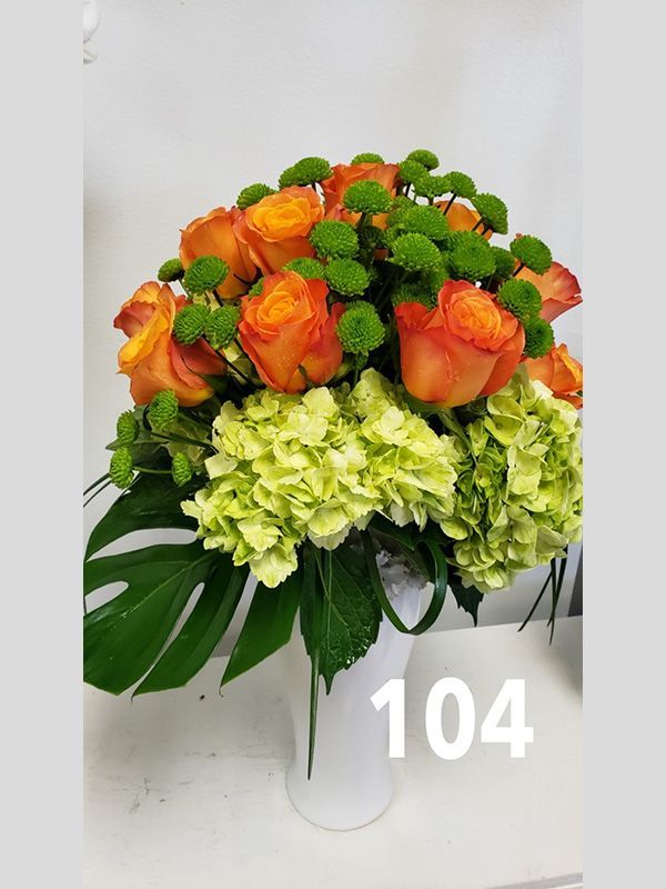 A bouquet of flowers in a vase with the number 104 on it