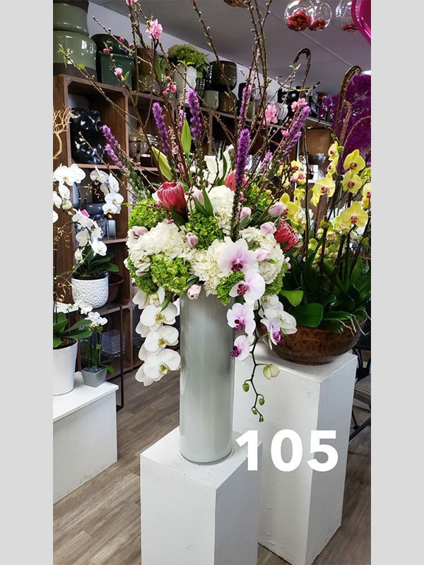 A large vase filled with flowers is on display in a store.