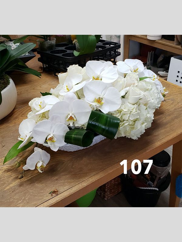 A bouquet of white flowers is sitting on a wooden table.