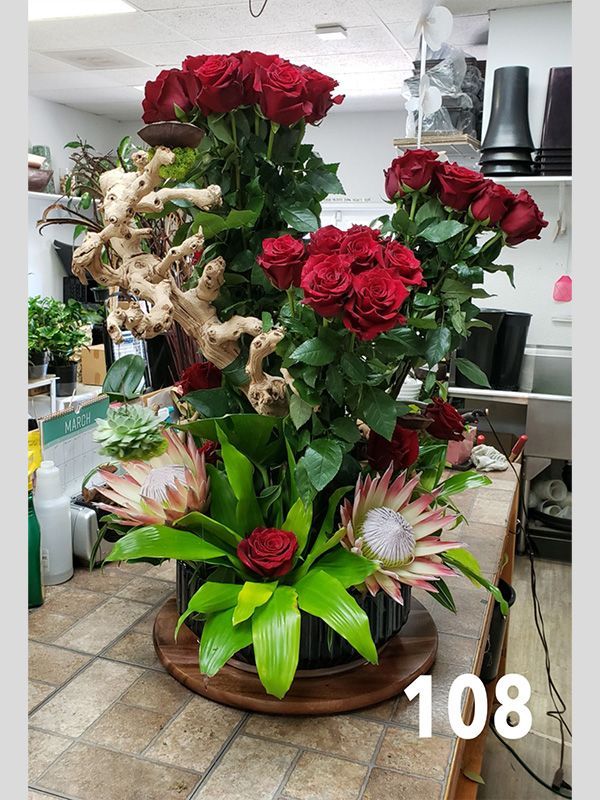 A large vase filled with red roses is sitting on a table.
