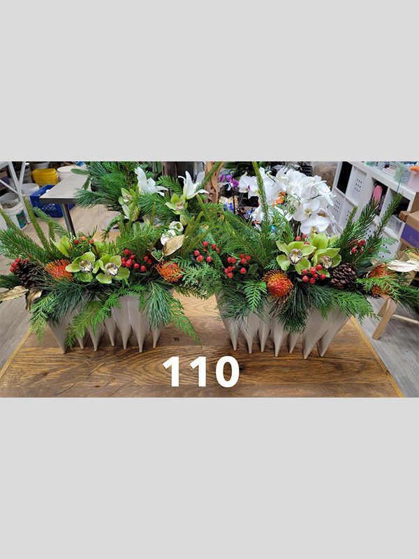 A couple of vases filled with flowers are sitting on top of a wooden table.