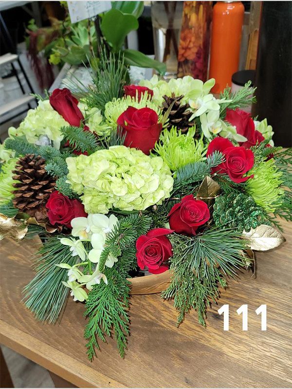 A bouquet of flowers is sitting on a wooden table.