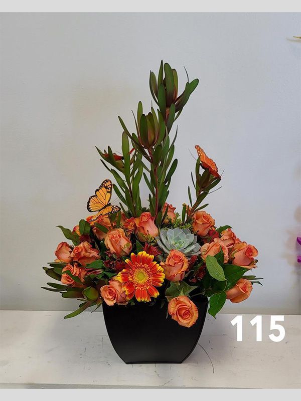 A vase of flowers with the number 115 on the bottom