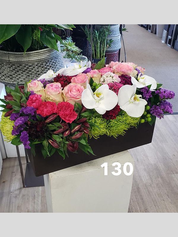 A box filled with flowers is sitting on a table.