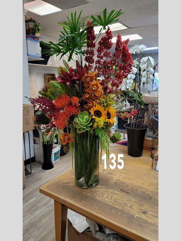 A vase filled with flowers is sitting on a wooden table.