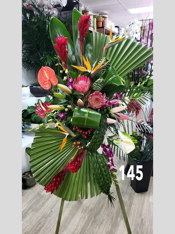 A large bouquet of tropical flowers on a stand in a flower shop.