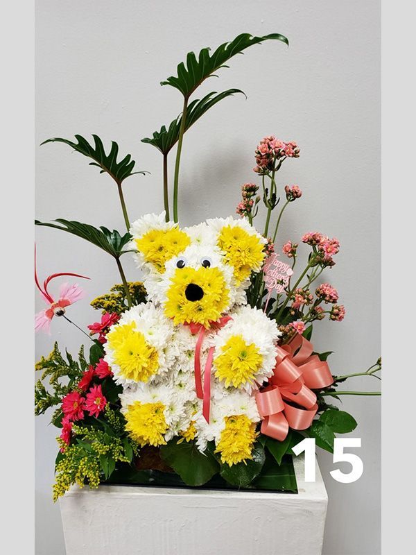 A teddy bear made out of yellow and white flowers