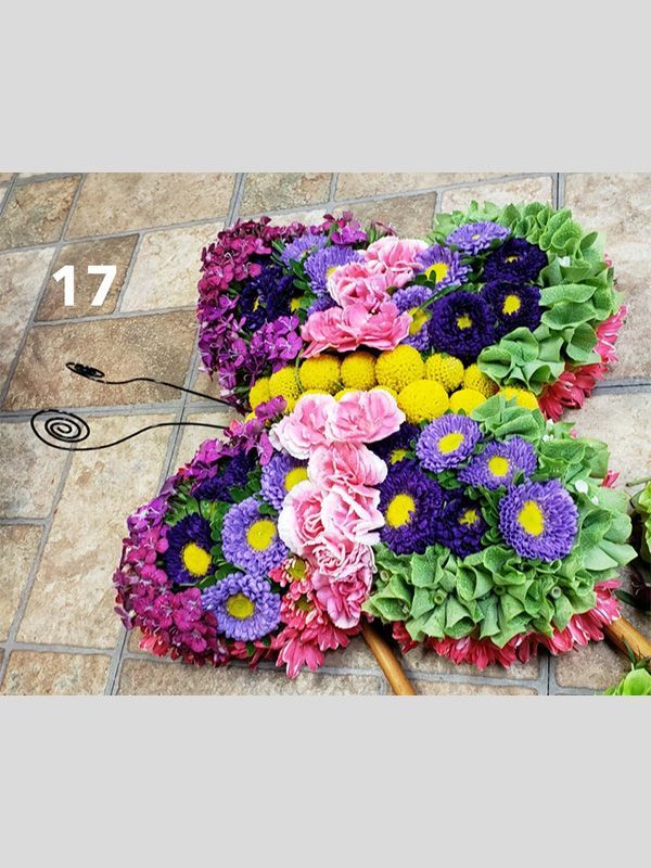 A butterfly made of flowers is sitting on a tiled floor.