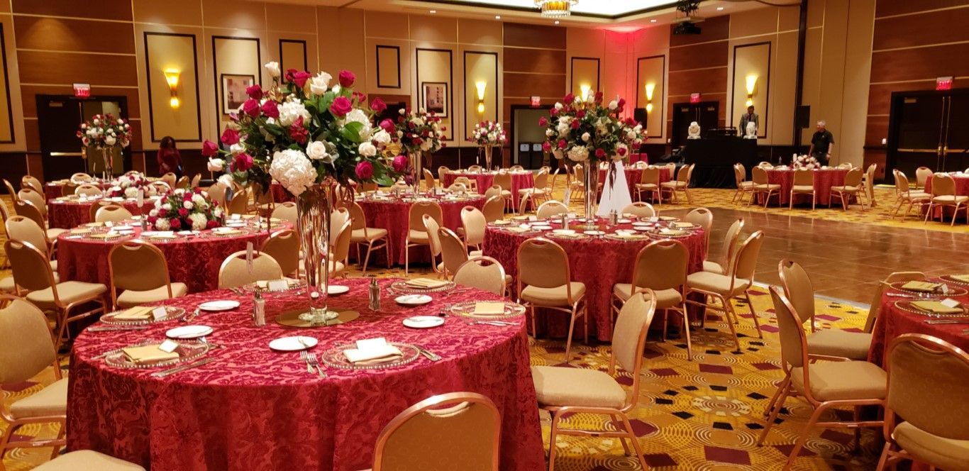 A large room with tables and chairs set up for a wedding reception.